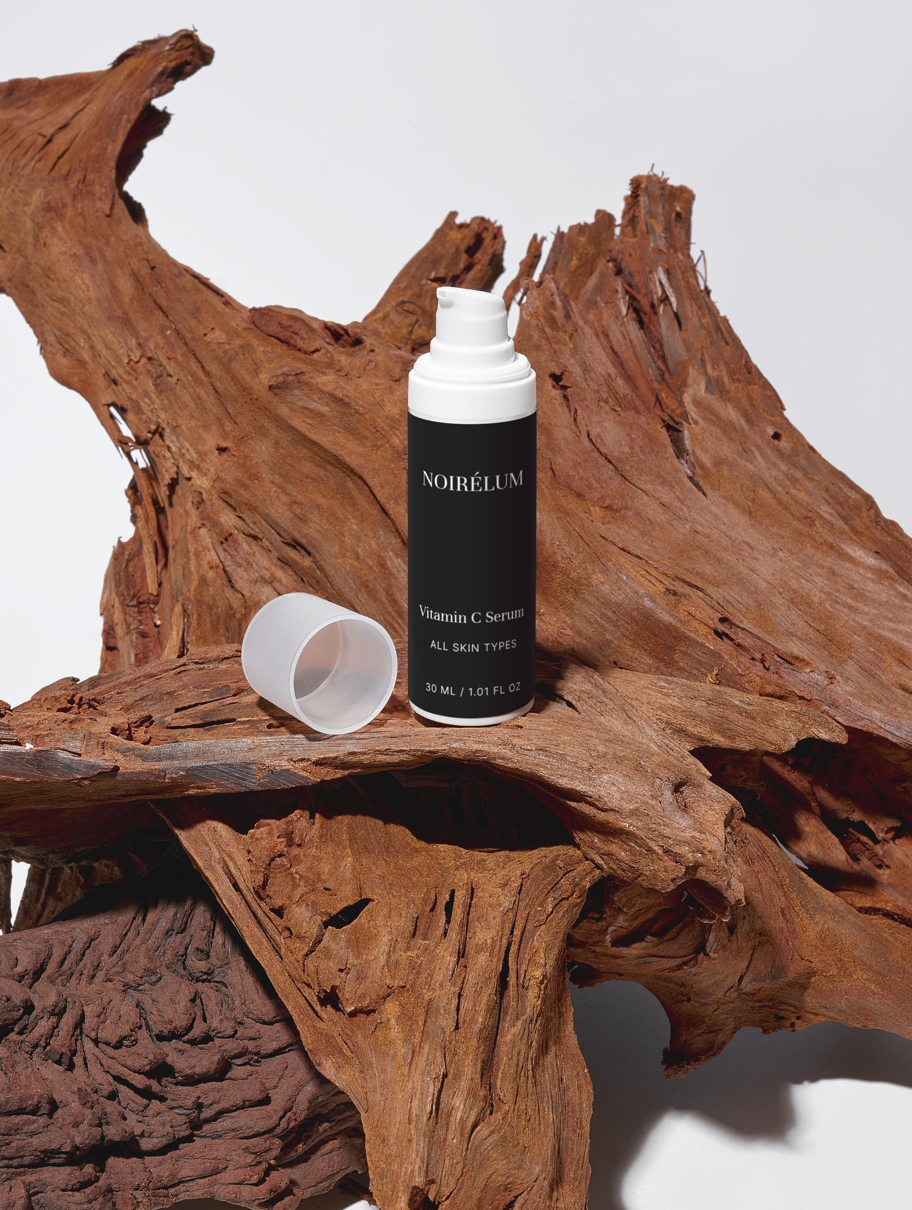 Vitamin C serum bottle on a wooden surface with a white background